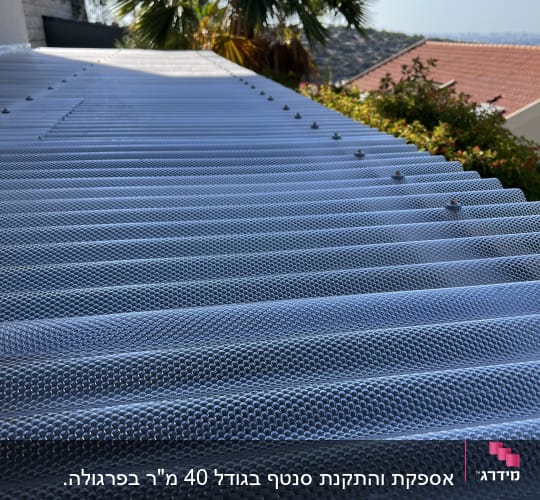 גג פלסטיק גלי עם ברגים ועצים ברקע